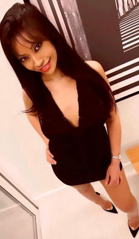 Pretty Thai girl in a black dress with a naughty smile on her face